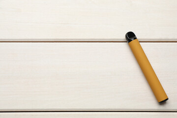 Disposable electronic cigarette on white wooden table, top view with space for text. Smoking alternative