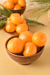 Bowl with tangerines on beige background