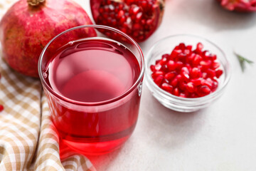 Glass of delicious pomegranate juice on white background