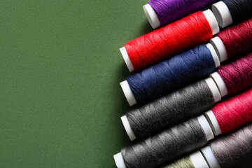 Different thread spools on green background