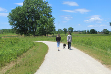 Mother and son walking their dog on a trail at James Pate Philip State Park in Bartlett, Illinois