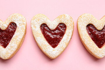 Tasty cookies in heart shape on pink background