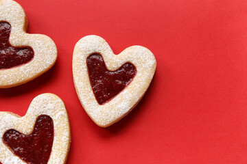 Obraz na płótnie Canvas Tasty cookies in heart shape on red background