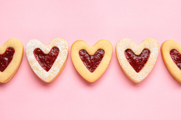 Obraz na płótnie Canvas Tasty cookies in heart shape on pink background