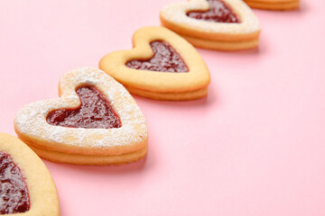 Tasty cookies in heart shape on pink background