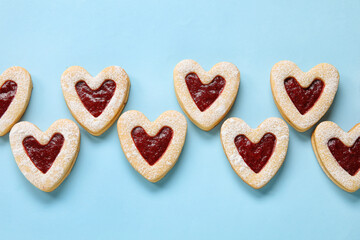 Tasty cookies in heart shape on blue background