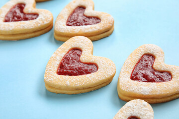 Tasty cookies in heart shape on blue background