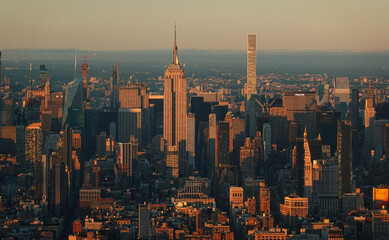 Fototapeta premium Sunset in New York, view from above. Amazing sun light over Manhattan and Hudson river during a sunset, images taken from the highest building in the city. Impressive architecture. Landmark of America