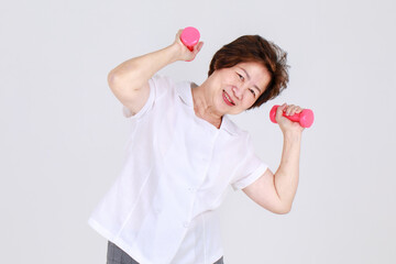 Healthy and strong senior woman happy and enjoy sport exercise by lifting up dumbbells to stretch...