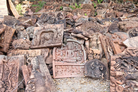 Many wreckage carved stone statue of buddha on the ground background