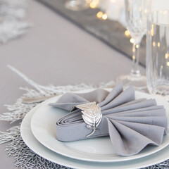 Beautiful table setting with Christmas decorations. Silver colors
