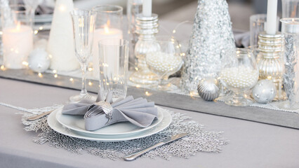 Beautiful table setting with Christmas decorations. Silver colors