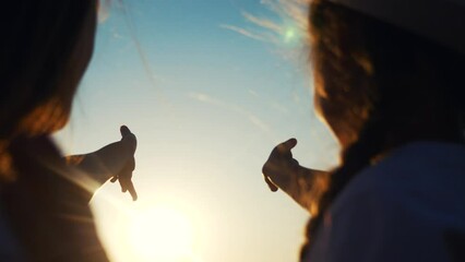 hands in the sun. mom and daughter hands reach out to the sun silhouette sunlight. happy family kid dream concept. mom and sunset daughter dream of god religion concept