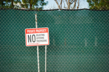 No trespassing or loitering sign on fence - obrazy, fototapety, plakaty