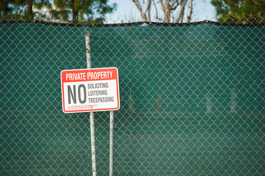No trespassing or loitering sign on fence