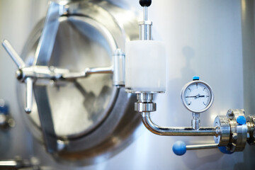 Equipment for the production of craft beer, containers for fermentation in the climatic chamber, pressure gauge with tubes and stainless steel tanks.