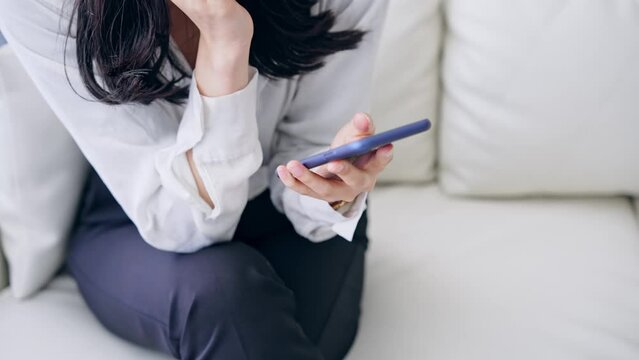 部屋でスマホを使う女性
