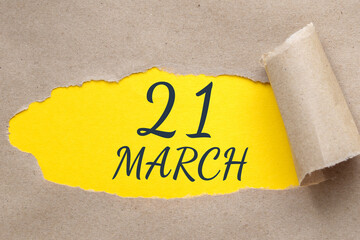 march 21. 21th day of the month, calendar date. Hole in paper with edges torn off. Yellow background is visible through ragged hole.Spring month, day of the year concept