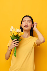 pretty brunette bouquet of flowers in hands spring fun posing yellow background unaltered