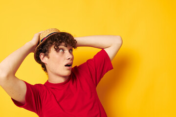 guy with red curly hair in a red t-shirt with a fashion hat yellow background unaltered