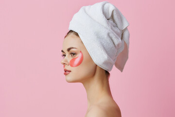 woman pink patches on the face with a towel on the head isolated background