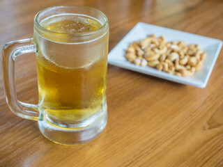 beer mug with cashew nut on a wooden table 