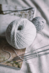 Balls of wool yarn with needles on a rustic background.  Concept for handmade and hygge slow life.