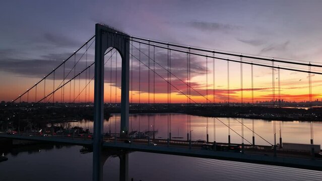 dusk flying clockwise around Bronx Whitestone Bridge with NYC in bkrd
