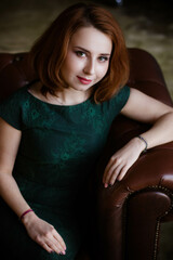 Naklejka premium red-haired woman in green dress posing
