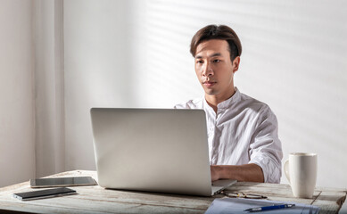 Male overwork. Tired Asian young man in white shirt alone in a dark room at home office, thoughtful, late home or financial difficulties and a lot of work Overthinking Unhappy upset and trouble idea