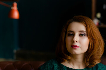 red-haired woman in green dress posing