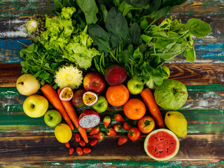 Fototapeta na wymiar Top view close up shot of various kinds of healthy tasty nutritious fresh raw natural organic agriculture vegan vegetables and fruits ingredient diet placed on old colorful wooden table background