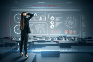 Back view of attractive young european woman standing on dark background with glowing digital hud business interface. Future, technology and innovation concept.