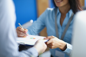 Female worker make correction on business paper with pen