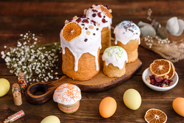 Fototapeta na wymiar Easter holiday concept. Easter cakes (orthodox kulich), willow, painted eggs and candle on rustic wooden table