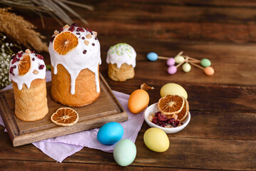 Fototapeta na wymiar Easter holiday concept. Easter cakes (orthodox kulich), willow, painted eggs and candle on rustic wooden table
