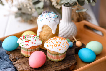 Festive cakes with white glaze, nuts and raisins with Easter eggs on the festive table