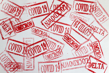 Red ink stamps covid19 and omicron delta lockdown closeup background