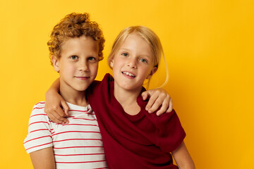 Boy and girl cuddling fashion childhood entertainment yellow background