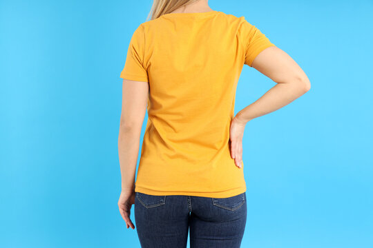 Woman in blank orange t-shirt on blue background