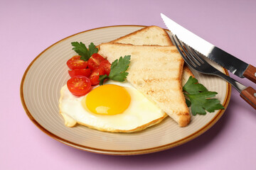 Plate of tasty breakfast on violet background