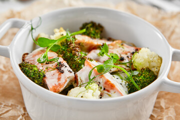 Healthy eating: steamed vegetables with salmon. Healthy salmon meal with broccoli and cauliflower. Casserole with fish and broccoli for lunch. Broccoli dish in diet menu. Cooked fish and veggies.