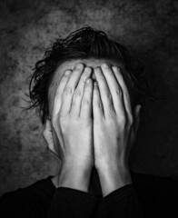 Young person covering their face, hidden face, I don't want to see anything, teenager his face...