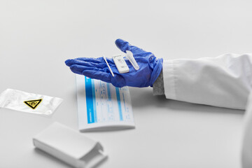 medicine, quarantine and pandemic concept - close up of doctor's hand in medical glove holding negative self testing coronavirus test on white background