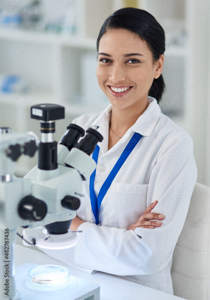 Poster medical research that makes a difference. portrait of a young scientist using a microscope in a labo