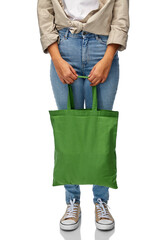 eco living, zero waste and sustainability concept - close up of woman with green reusable canvas bag for food shopping over white background