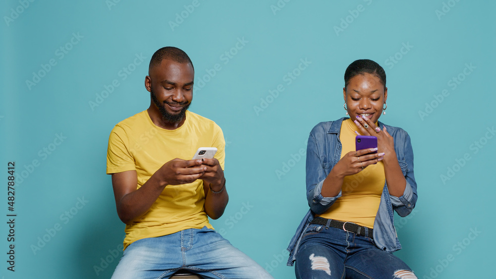 Poster modern people looking and smartphone screen and using technology to have fun in front on camera. cou