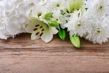 Lily, hortensia and chrysanthemum flowers on wooden background