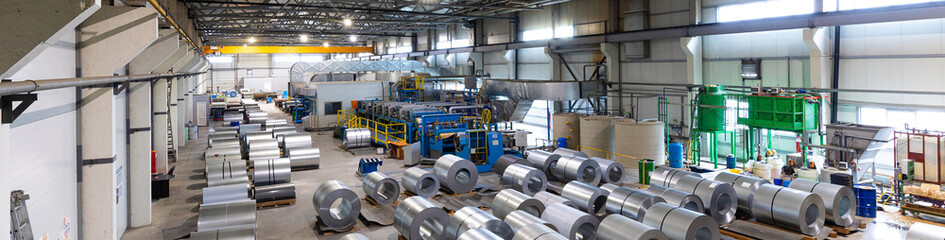 Obraz na płótnie Canvas Panoramic photo shot. Steel roofing forming machine. Industrial machine for metal sheet roof coils cut. Process of making steel tile for roof