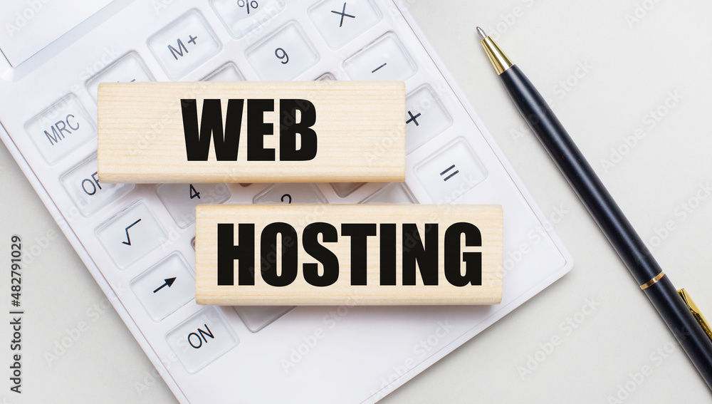 Poster wooden blocks with the web hosting iie on a light background on a white calculator. nearby is a blac